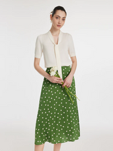 a lady in a bow tie neck knit top and mulberry silk green polka dots printed skirt